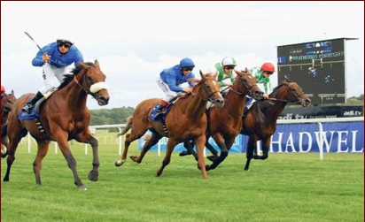 Balladore wins the Emirates Airline Premier Handicap Stakes under Denis Batteate at Newbury Racecourse.